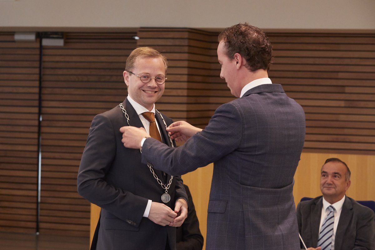 Burgemeester Richard Korteland ontvangt de ambtsketting van wethouder Arjen Maathuis